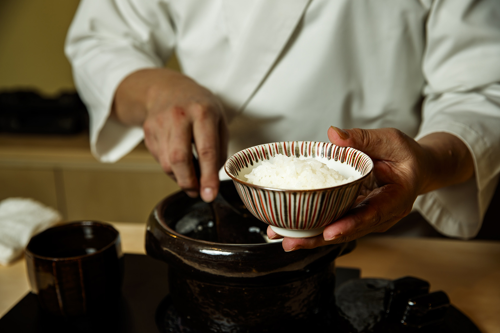 土鍋ご飯をよそう店主の手元